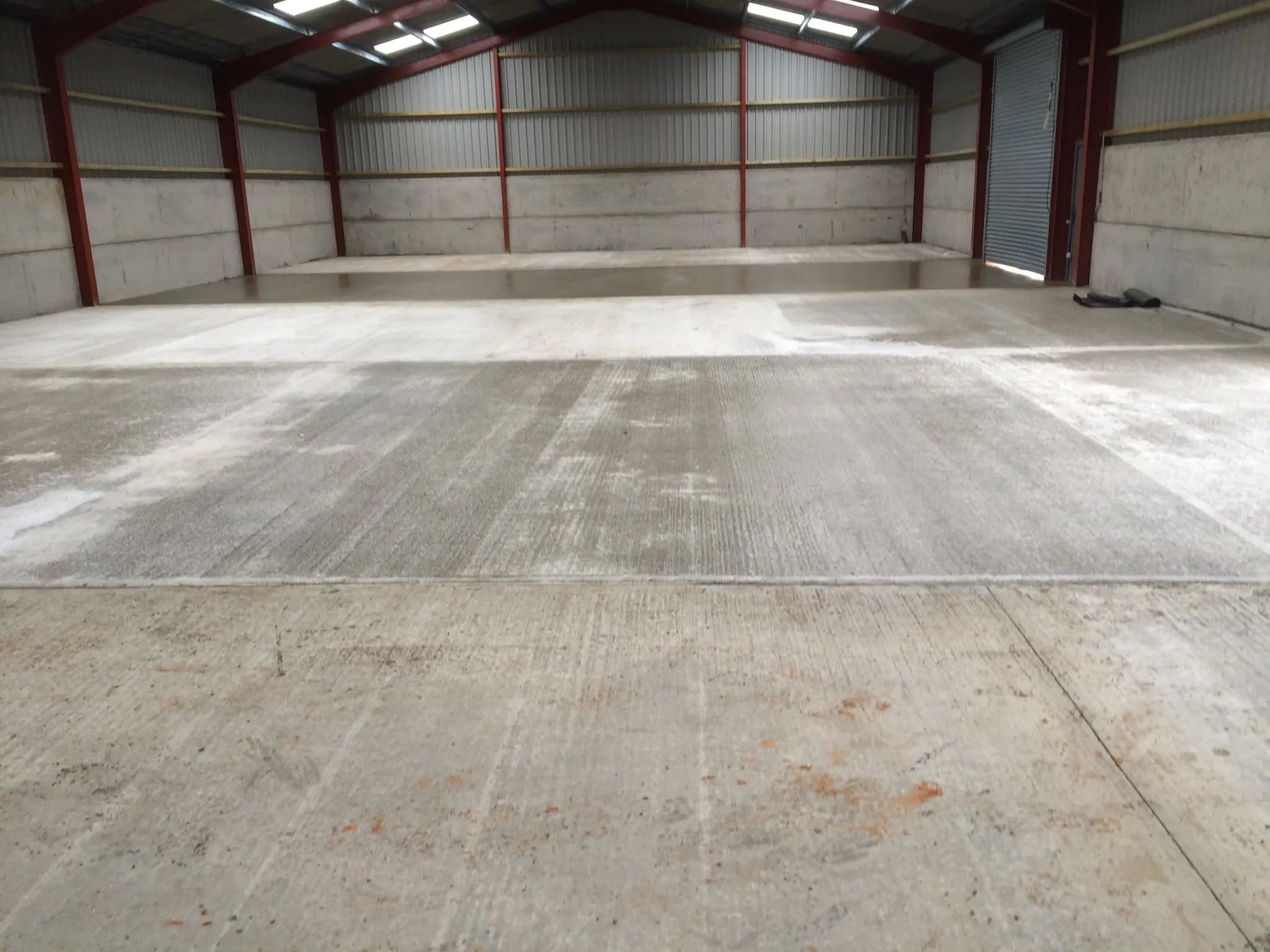 Completed power-floated concrete floor inside a finished building, smooth and level throughout