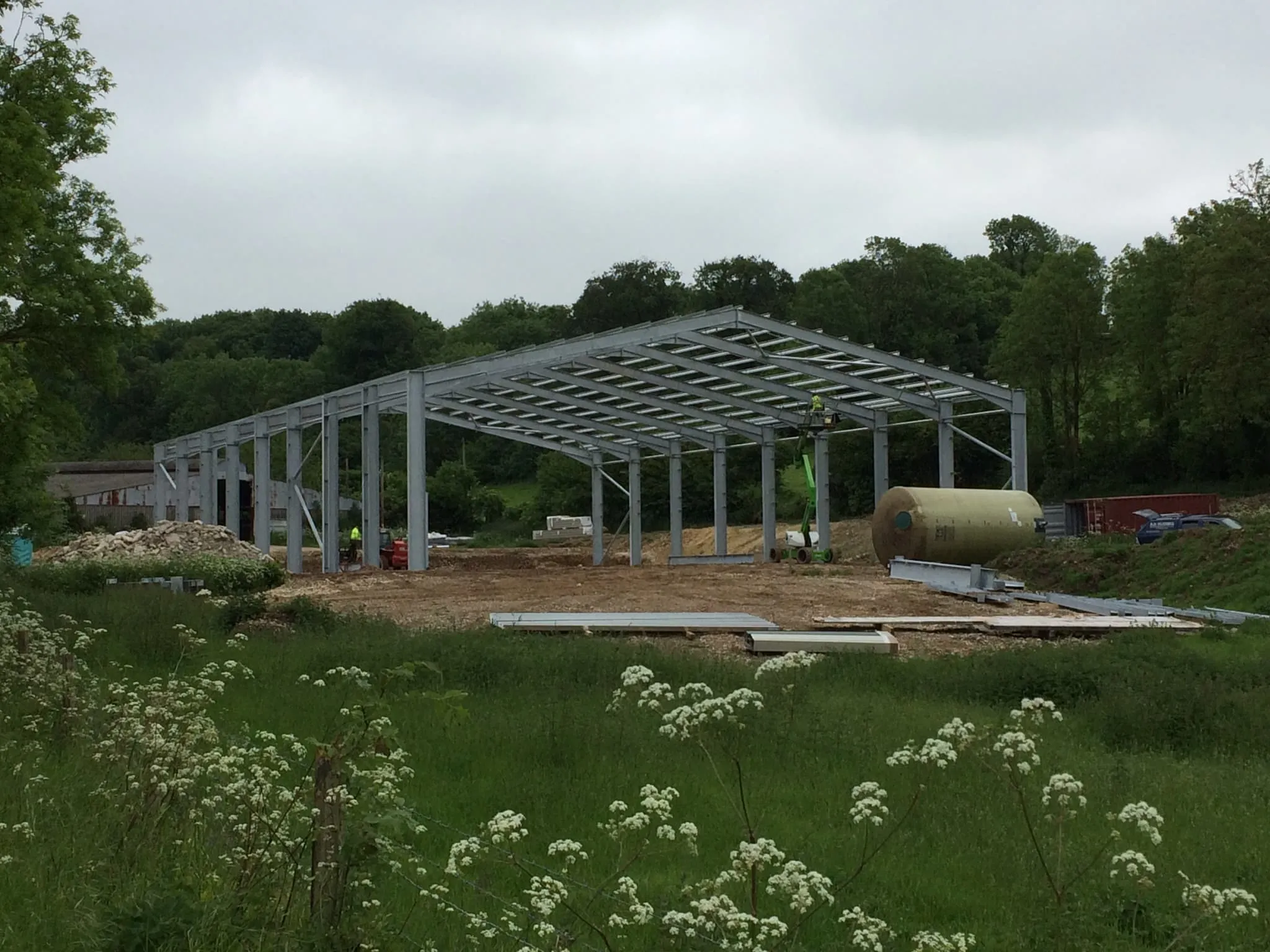 Completed galvanised steel frame standing in a meadow of long grass and cow parsley