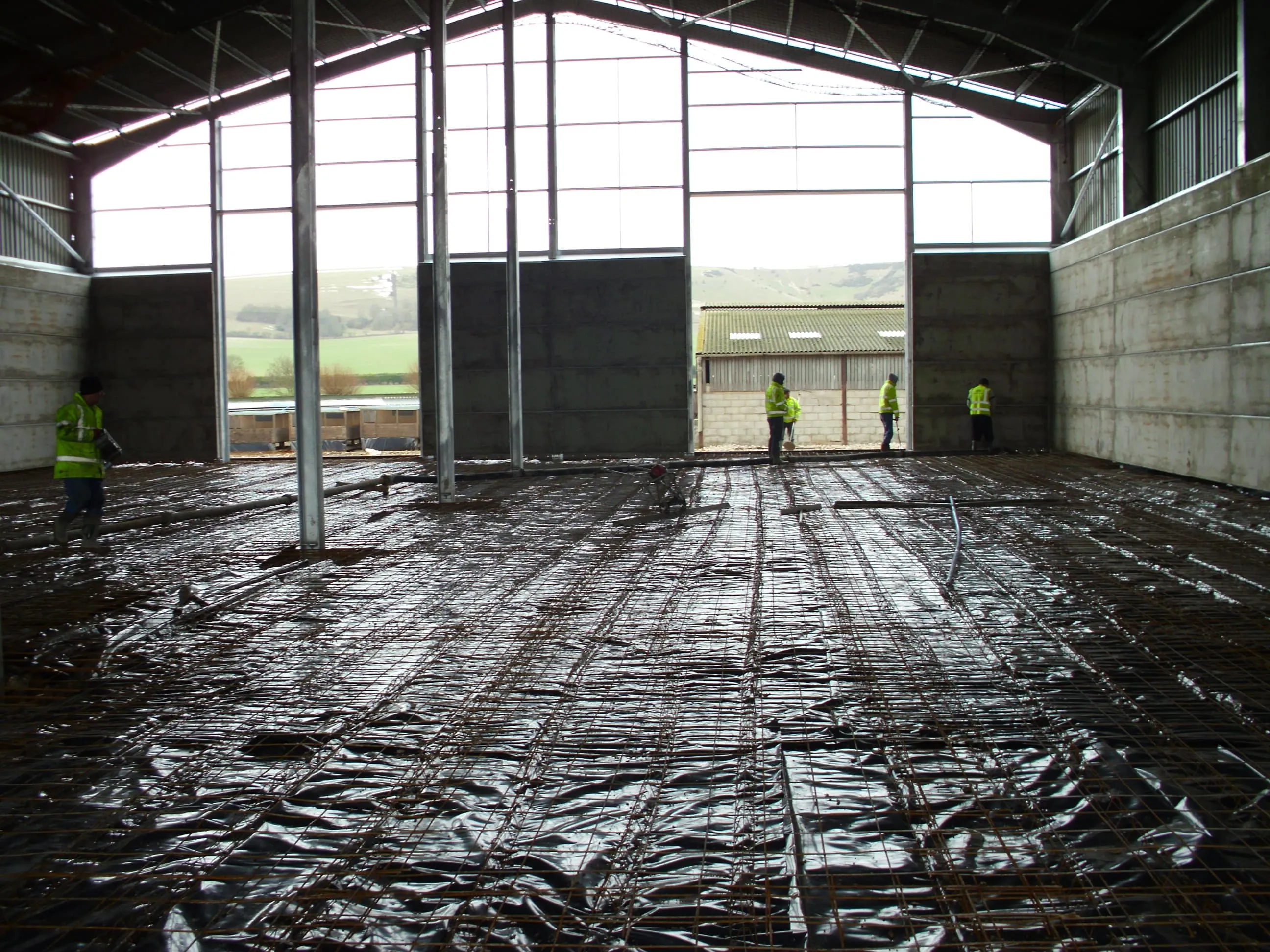 Reinforcement and damp-proof membrane laid across a prepared base inside a concrete panel building, ready for pouring